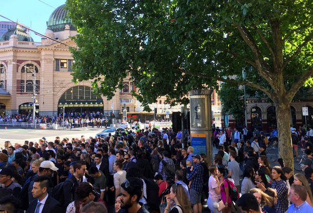 Members of the public stand behind police tape after Australian police said on Thursday they have arrested the driver of a vehicle that ploughed into pedestrians at a crowded intersection near the Flinders Street train station in central Melbourne 
