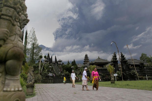 Balinese Hindus walk after praying as Mount Agung volcano erupts at Besakih Temple in Karangasem, Bali 